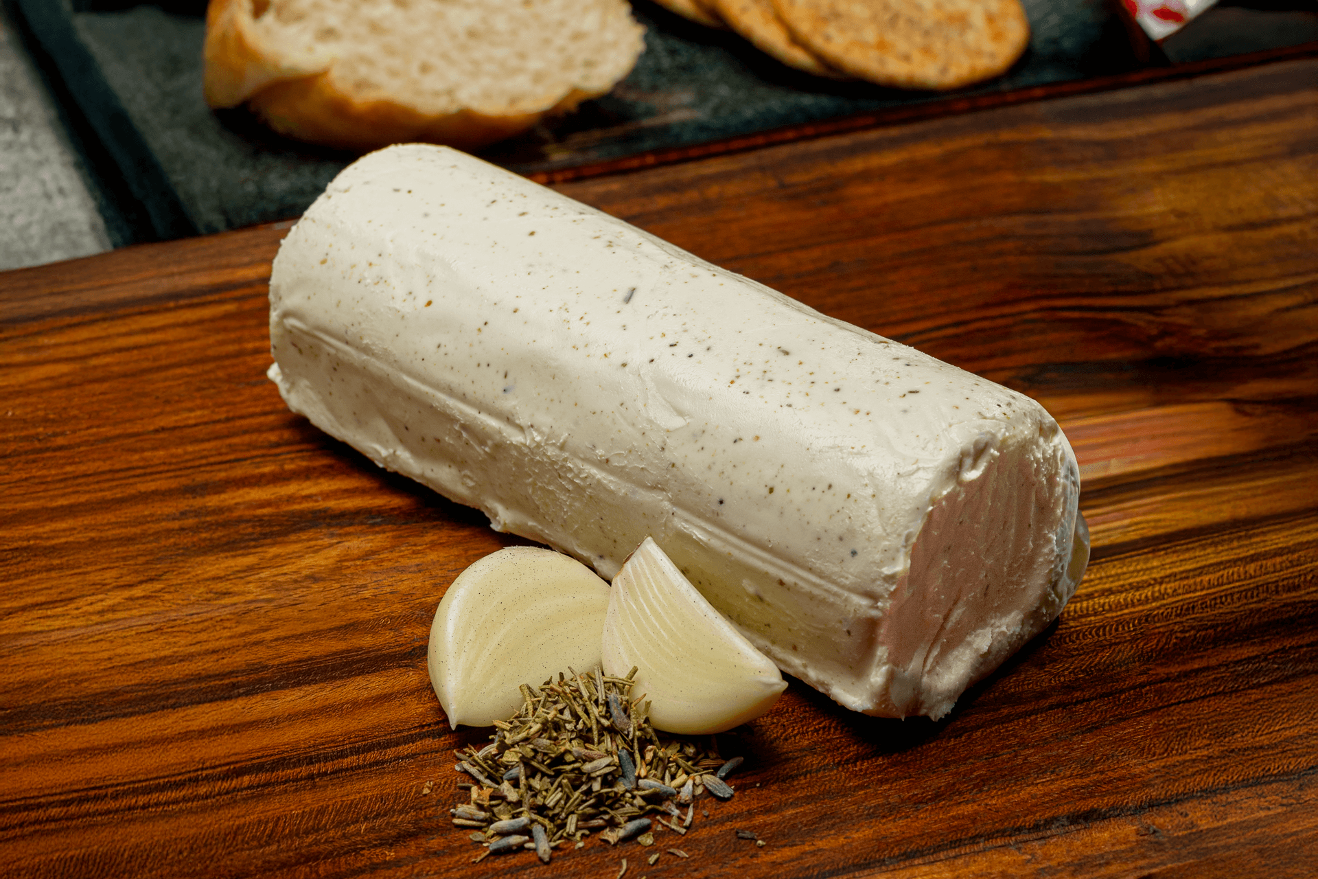 Rulo de queso de cabra Le Blanc a las finas hierbas y ajo preparado para el consumo, destacando la calidad de los ingredientes y el acabado artesanal.